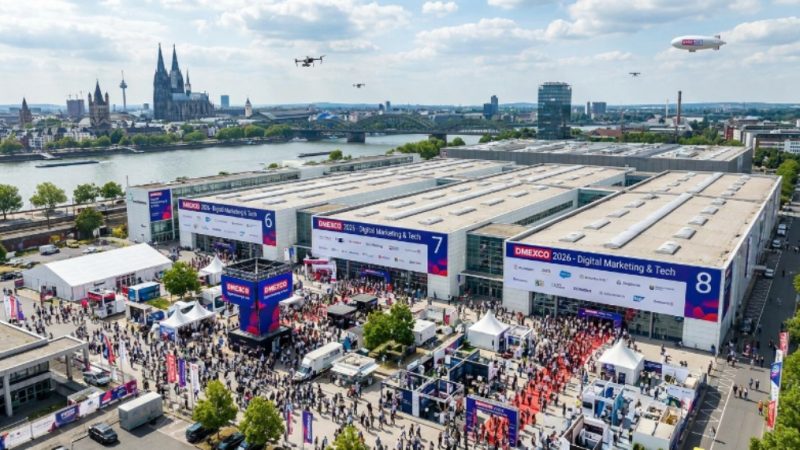 Aerial view of the Koelnmesse exhibition centre in Cologne, Germany, with large crowds of visitors attending DMEXCO 2026 across Halls 6, 7, and 8